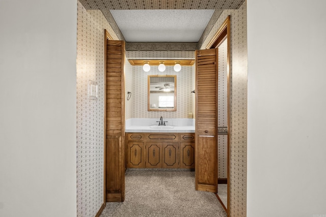 bathroom featuring wallpapered walls and vanity