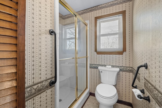 bathroom with a shower stall, wallpapered walls, and toilet