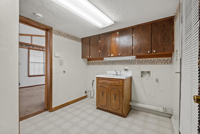 laundry room with light floors, washer hookup, cabinet space, electric dryer hookup, and a sink