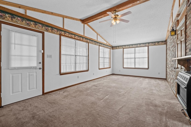 unfurnished living room featuring ceiling fan, vaulted ceiling with beams, carpet floors, and a textured ceiling