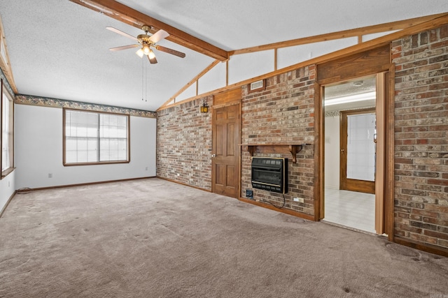 unfurnished living room with lofted ceiling with beams, a textured ceiling, carpet floors, a brick fireplace, and ceiling fan