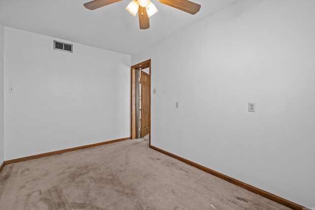 empty room featuring visible vents, baseboards, carpet, and a ceiling fan