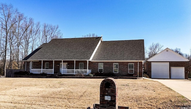 view of front of house with an outbuilding, brick siding, a porch, and a shingled roof