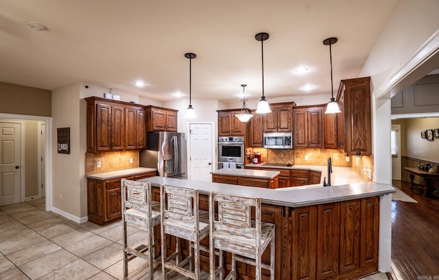 kitchen featuring decorative backsplash, appliances with stainless steel finishes, a kitchen island, and light countertops