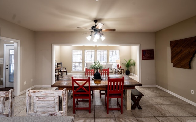 tiled dining area featuring baseboards and a ceiling fan