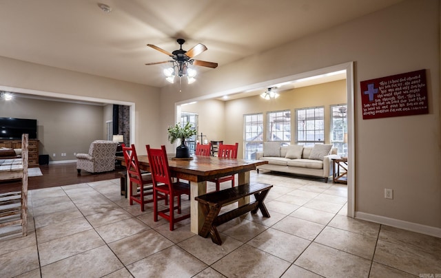 dining space with light tile patterned flooring, a ceiling fan, and baseboards