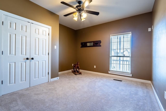 unfurnished bedroom featuring a closet, baseboards, and carpet flooring