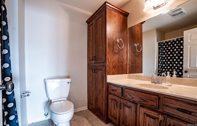 bathroom with vanity, visible vents, baseboards, tile patterned flooring, and toilet