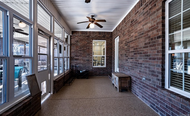 unfurnished sunroom with a ceiling fan