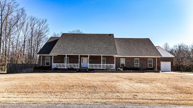 view of front of home with an attached garage, brick siding, and covered porch