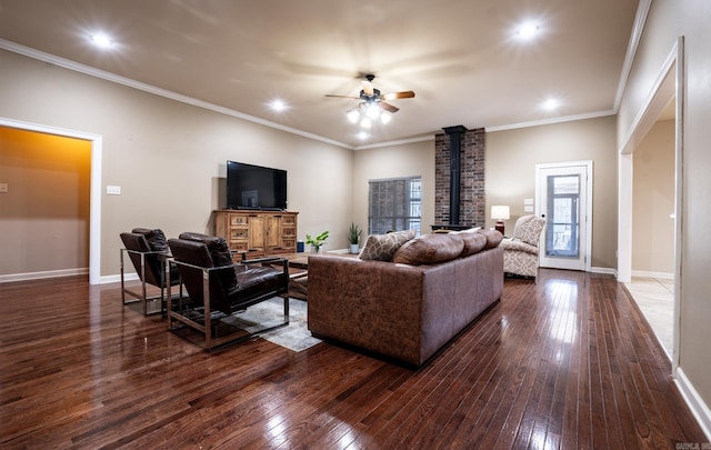 living area featuring dark wood finished floors, baseboards, a wood stove, and a ceiling fan