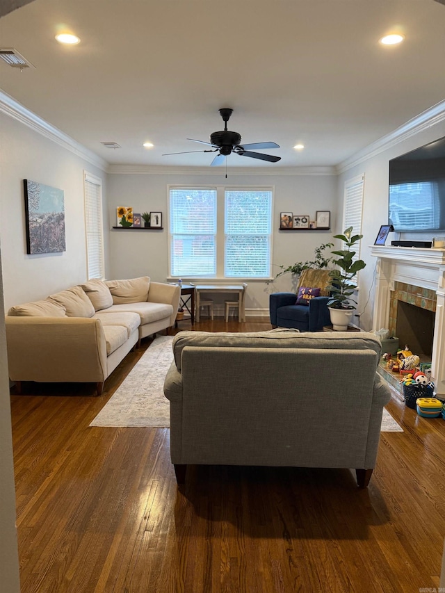 living room featuring dark wood finished floors, a ceiling fan, visible vents, and ornamental molding