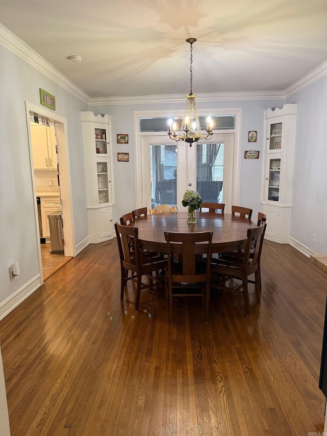 dining room with dark wood-type flooring, a notable chandelier, and ornamental molding