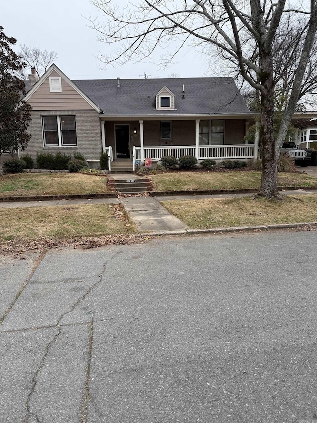 view of front of property with covered porch and a front lawn