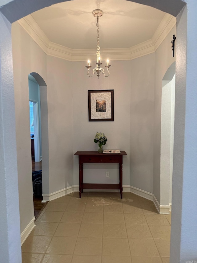 hallway with arched walkways, a chandelier, light tile patterned flooring, and ornamental molding