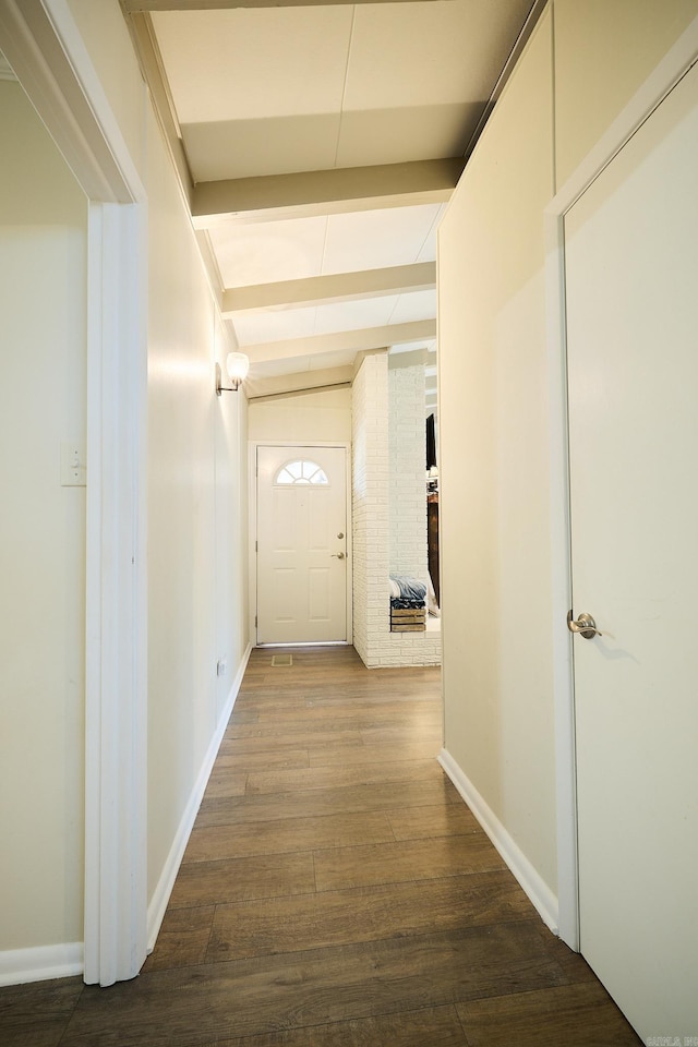 corridor featuring beamed ceiling, baseboards, and dark wood-style flooring