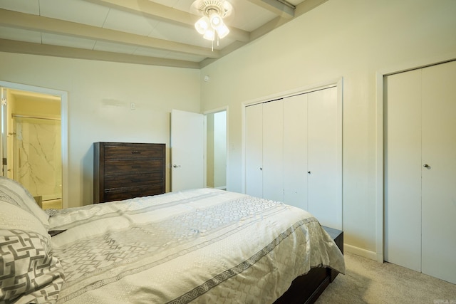 bedroom with two closets, carpet, and vaulted ceiling with beams