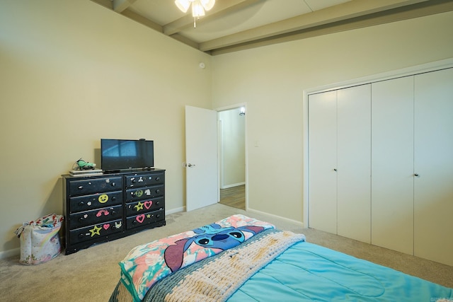 bedroom featuring beamed ceiling, a closet, carpet flooring, baseboards, and ceiling fan