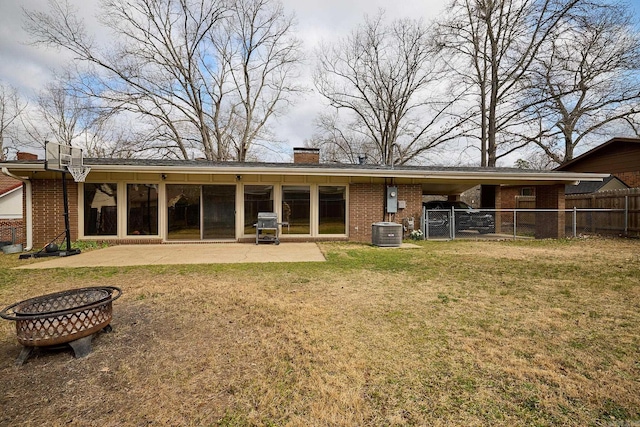 back of property featuring fence, a chimney, a lawn, a patio area, and brick siding