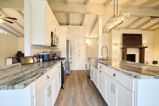 kitchen with stainless steel appliances, light stone countertops, ceiling fan, and white cabinets