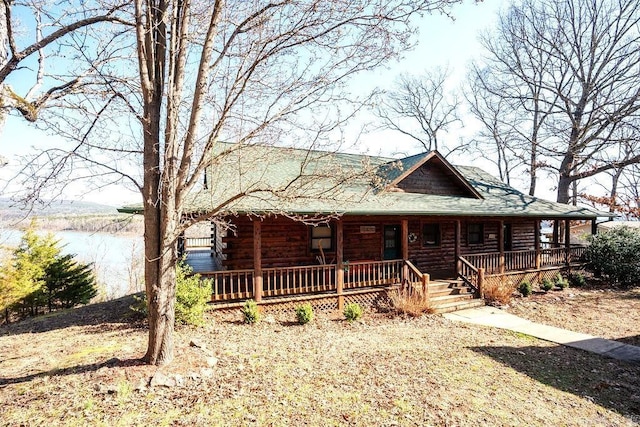 cabin with a porch and log exterior