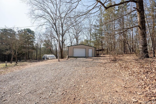 exterior space with an outbuilding, driveway, and a garage