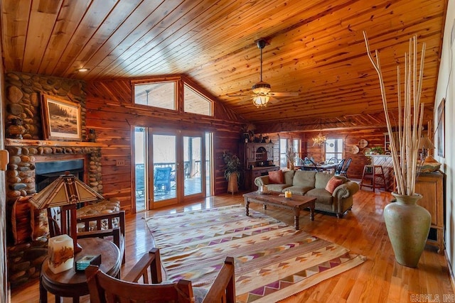 living room with ceiling fan, wood walls, wood ceiling, wood finished floors, and high vaulted ceiling