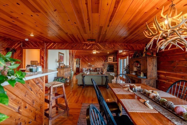 unfurnished dining area with wood finished floors, wood ceiling, wood walls, and a ceiling fan