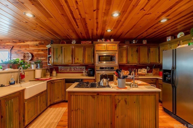 kitchen with an island with sink, light countertops, recessed lighting, appliances with stainless steel finishes, and a sink