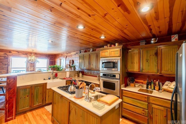 kitchen featuring a sink, stainless steel appliances, a peninsula, and light countertops