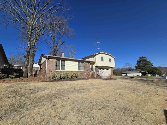 view of front of home featuring brick siding, an attached garage, and a chimney