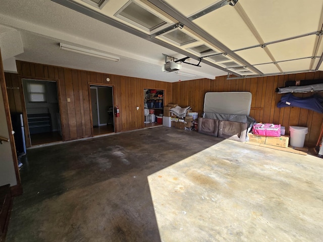 garage with wooden walls and a garage door opener