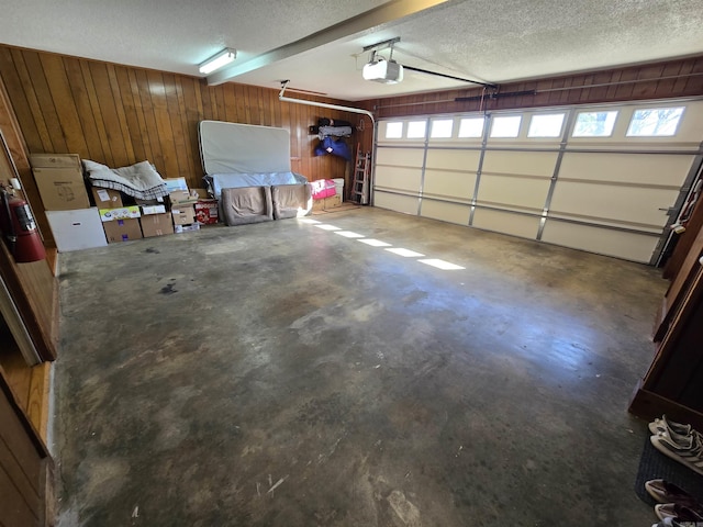 garage featuring wooden walls and a garage door opener