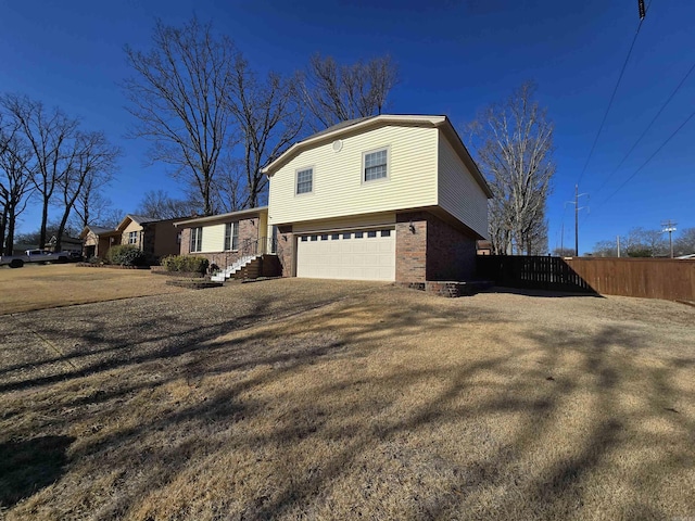 view of side of home with an attached garage and fence