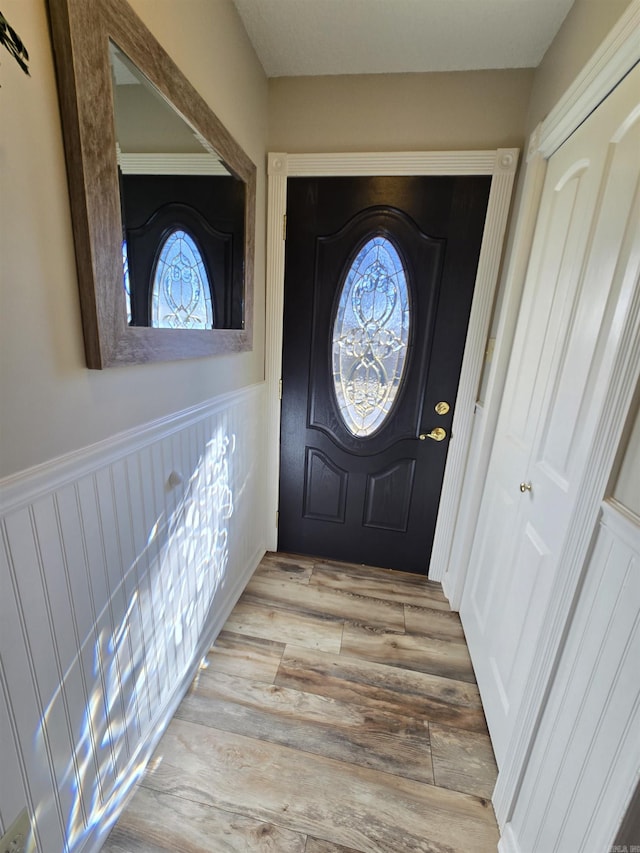 entrance foyer with wood finished floors and wainscoting