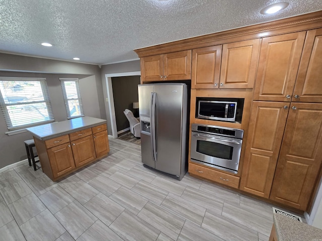 kitchen featuring visible vents, brown cabinets, appliances with stainless steel finishes, and a center island