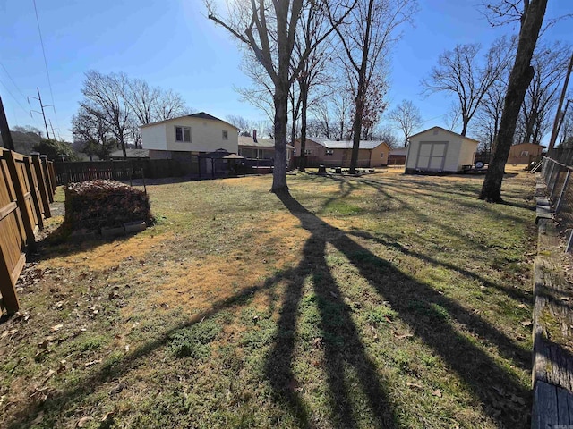 view of yard with a storage unit, an outbuilding, and a fenced backyard