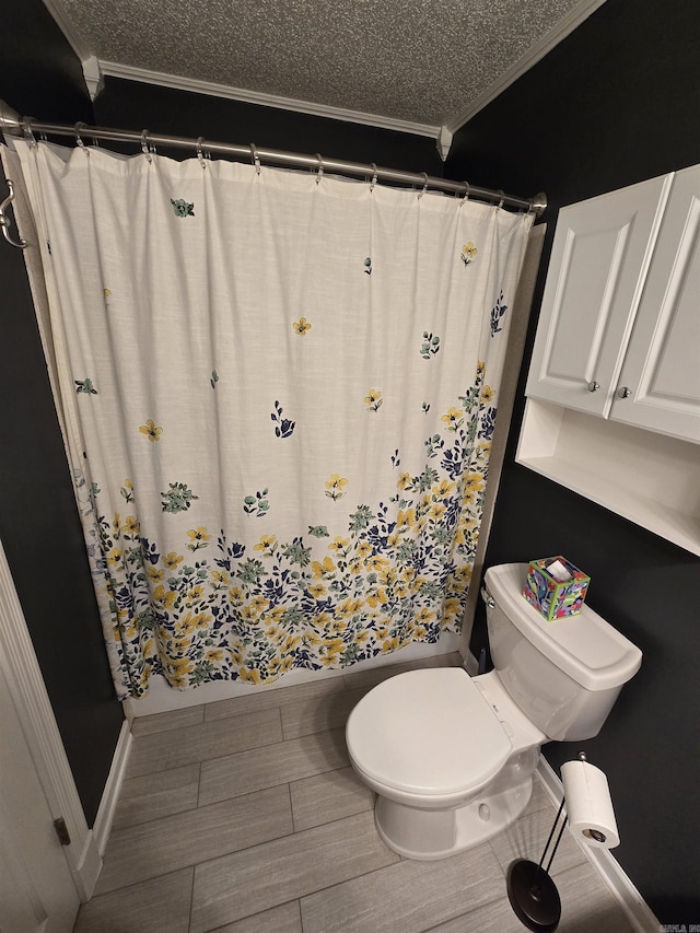 full bathroom featuring toilet, a textured ceiling, a shower with curtain, and ornamental molding