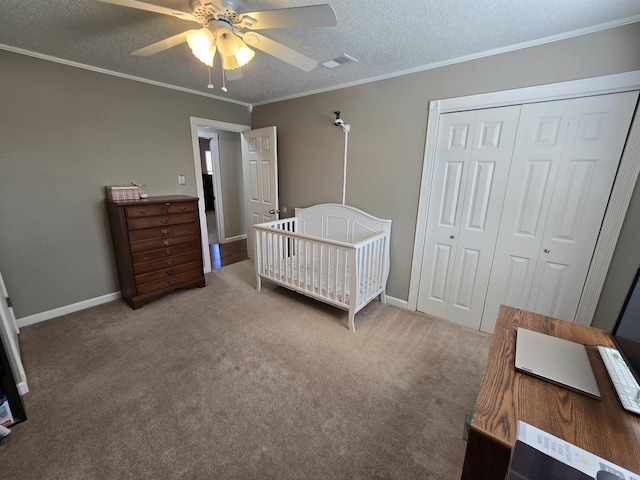 carpeted bedroom with a closet, a textured ceiling, crown molding, and baseboards