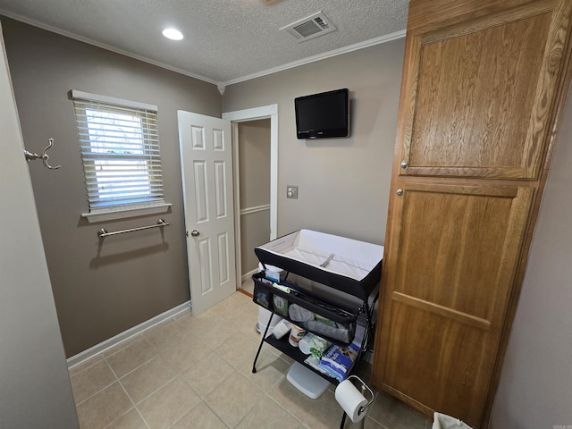 office space featuring light tile patterned floors, baseboards, visible vents, a textured ceiling, and crown molding