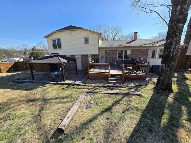 rear view of house featuring a gazebo, fence private yard, a lawn, and a patio area