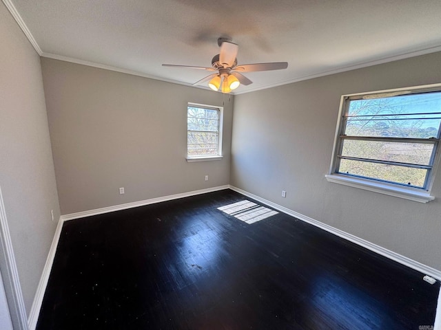 spare room featuring baseboards, dark wood finished floors, a ceiling fan, and ornamental molding