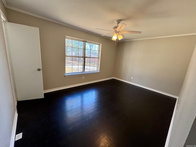 spare room with crown molding, dark wood-style floors, a ceiling fan, and baseboards