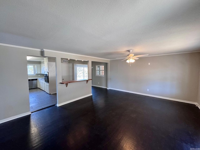 unfurnished room featuring a textured ceiling, a healthy amount of sunlight, baseboards, and ceiling fan