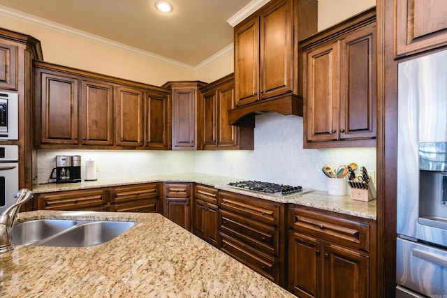 kitchen with light stone counters, ornamental molding, backsplash, and stainless steel appliances