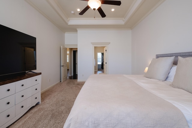 bedroom with ornamental molding, a tray ceiling, recessed lighting, baseboards, and light colored carpet