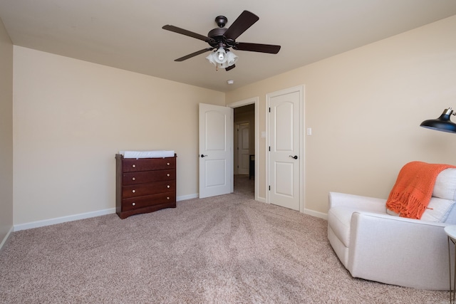 living area featuring carpet, baseboards, and ceiling fan