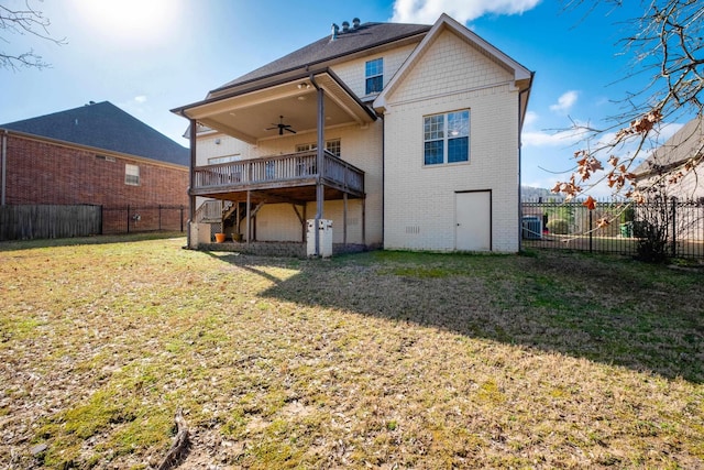 back of property featuring brick siding, a fenced backyard, a deck, a yard, and a ceiling fan