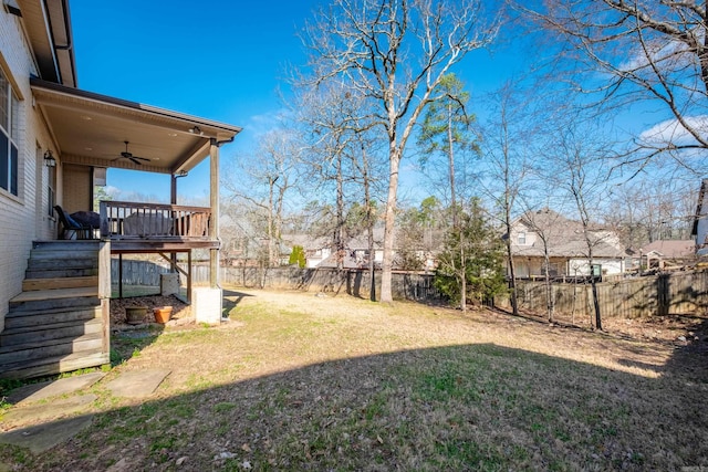 view of yard featuring stairs, a deck, a ceiling fan, and a fenced backyard