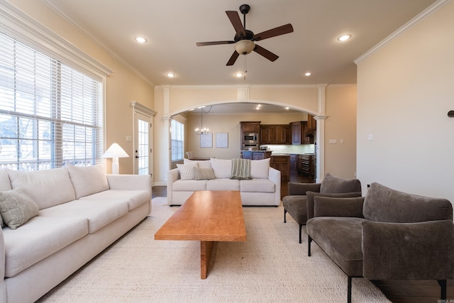 living room with arched walkways, recessed lighting, ceiling fan, and ornamental molding